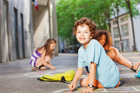 Portrait of a boy draw with friends on the streetの写真素材