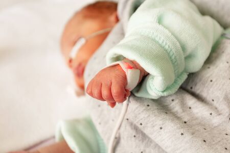 Newborn hand and heart monitor attached closeupの写真素材