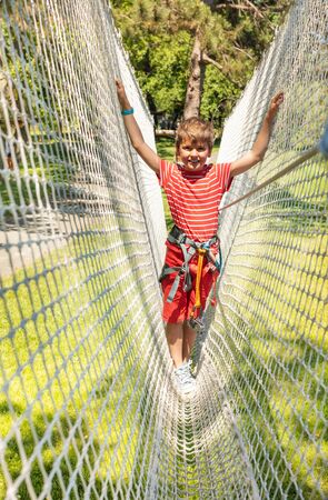 Boy on the net in adventure rope climbing parkの写真素材