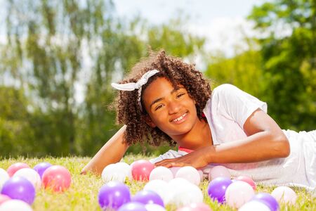 Portrait of a young girl laying in the lawn grassの写真素材
