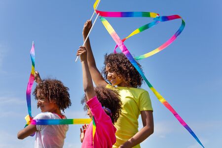 Three beautiful girls waving with color ribbonsの写真素材