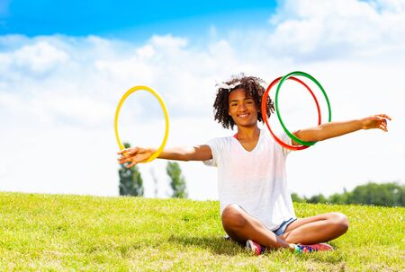 Young girl with curly hair rotate hoops in handsの写真素材