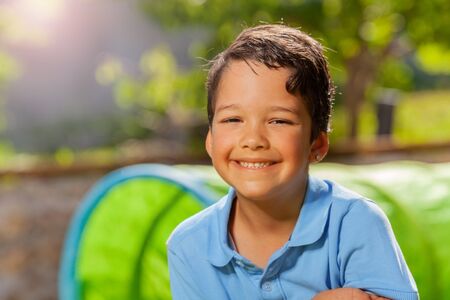 Summer day close portrait of a smiling cute boyの写真素材