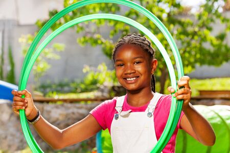 Happy black smiling girl with hula hoop ringsの写真素材