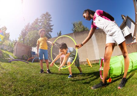 Boy jump through hula hoop ring on playground