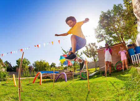 Boy jump over strings passing course of obstaclesの写真素材