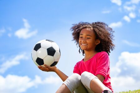 Beautiful black girl portrait with football ballの写真素材
