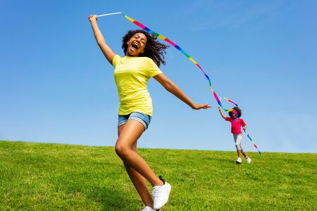 Happy positive girl run and scream with ribbon