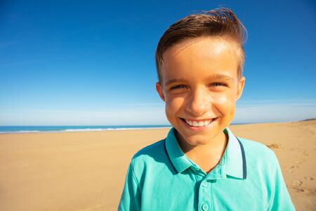 Boy with cute smile on the sea sand beach portrait