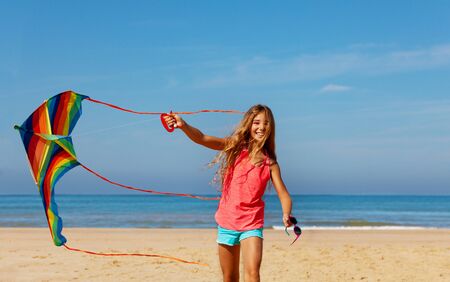 Happy beautiful carefree girl with bright kiteの写真素材