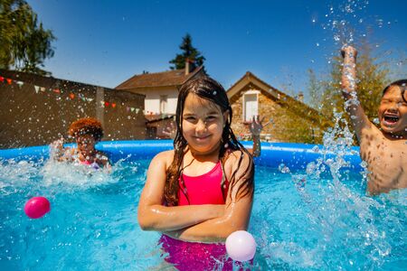 little girl pose in swimming pool with friends