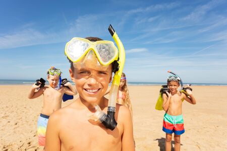 Boy in snorkeling mask, group of friends on beachの写真素材
