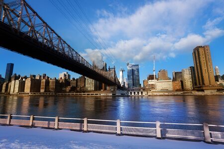 Winter view of Ed Koch Queensboro Bridge over New York buildings across East river from Roosevelt...