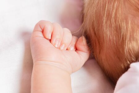 Tiny hand fist close-up of newborn infant baby boy sleepingの写真素材