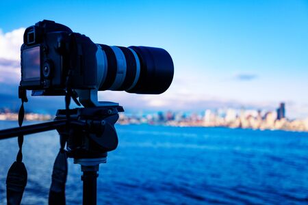 Camera on tripod photographing American city panorama with long lens