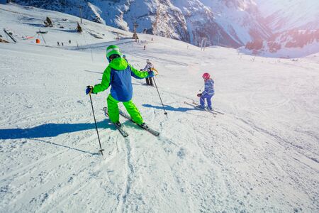 Group of children ski on the hill with friends portrait, sunny day on Alpine mountain resortの写真素材
