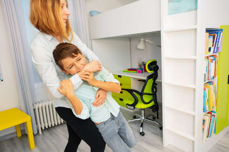 Close portrait of little autistic boy bite hands with strong negative face expression, throwing tantrumsの写真素材