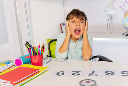 Boy with autism spectrum disorder learn numbers but scream and close ears in the class, sensory...