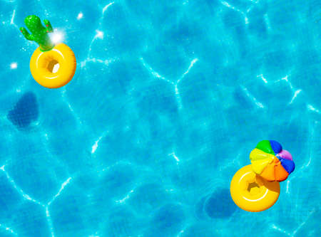 Inflatable yellow sun umbrella and cactus buoys swim in the swimming pool view with perspective