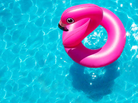 Inflatable flamingo buoy swim in the swimming pool view from aboveの写真素材