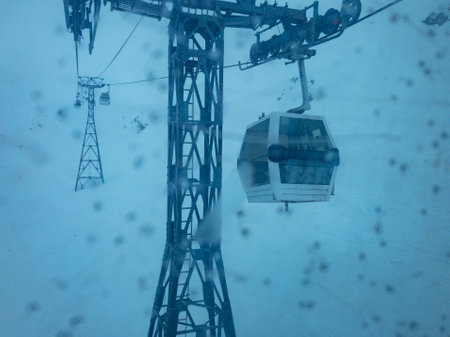 Storm and heavy snowfall in the mountains view of ski lift cabin with low visibilityの写真素材