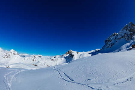 Panorama of mountain tops in French alps at winter on sunny day with blue skyの写真素材