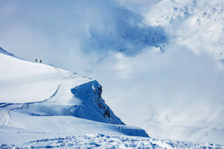 Cliff covered with snow high in the French Alps mountains during winter near ski trailsの写真素材