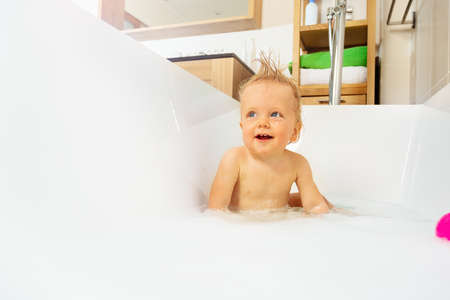 Bathing portrait of a little blond toddler boyの写真素材