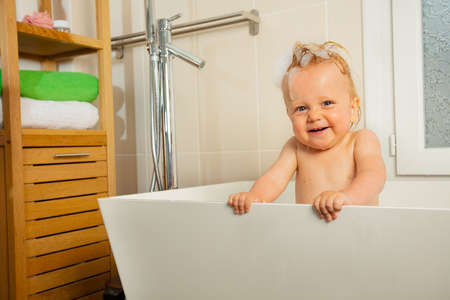 Laughing portrait of toddler boy in bath with foamの写真素材