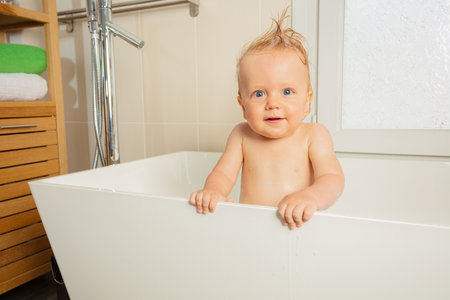 Handsome little toddler boy portrait in a bathtubの写真素材
