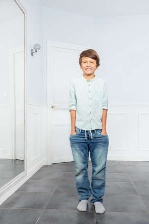 Full height portrait of happy boy stand in a roomの写真素材