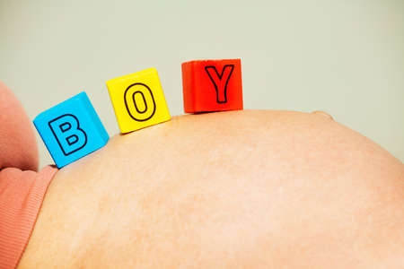 Its a boy - word made of blocks on pregnant bellyの写真素材