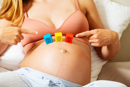 Woman points to boy word made of letters on bellyの写真素材