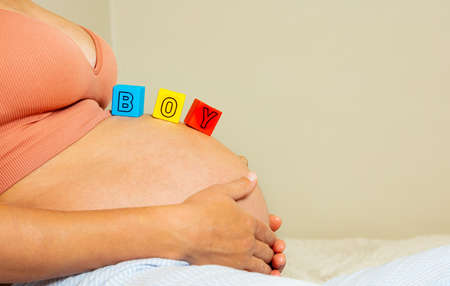 Womans belly with boy word made out of blocksの写真素材