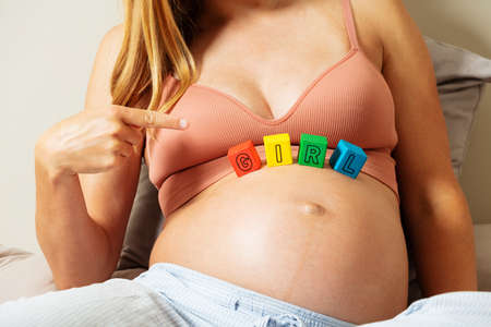Pregnant expecting woman point to girl wordの写真素材