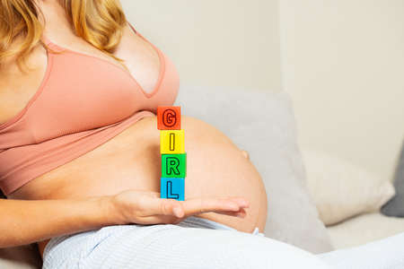 Pregnant woman hold girl word of blocks stackの写真素材