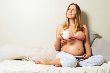 Relaxed photo of a pregnant woman sit with teaの写真素材