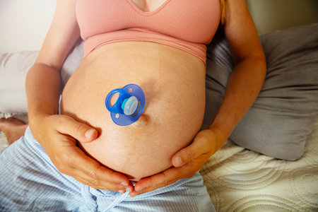 Pacifier on the belly of a pregnant woman from topの写真素材