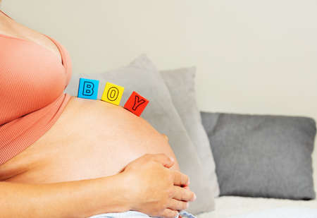 Third trimester woman belly and boy word of blocksの写真素材