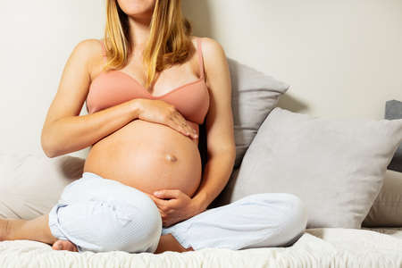 Woman touch big pregnant belly close-up imageの写真素材