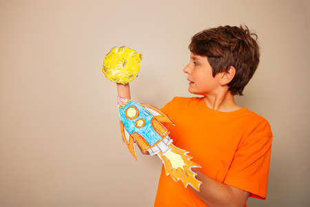 Cute young boy play with rocket land on a planetの写真素材