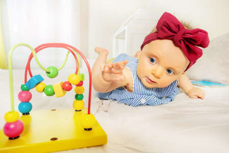 Infant girl stretch to bead roller coaster toyの写真素材
