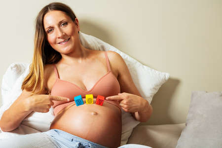 Smiling pregnant expecting woman show boy wordの写真素材