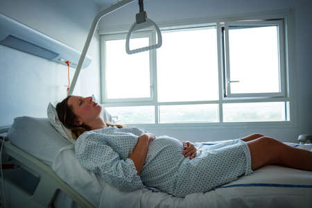 Pregnant woman in pain during labor at hospitalの写真素材