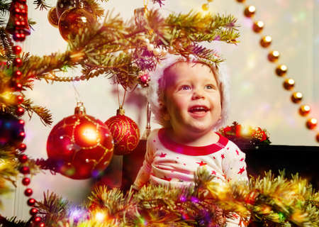 Excited little toddler boy looks at Christmas treeの写真素材