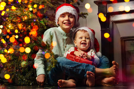Two brothers boys sit with Christmas presentの写真素材