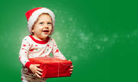 Toddler boy hold present box wearing Santa hatの写真素材