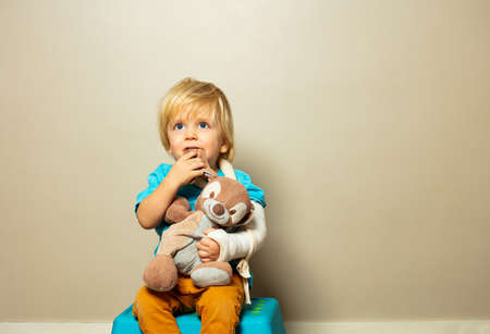 Boy with broken hand in plaster hug little rabbitの写真素材