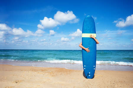 Man surfer hold surf board with hands, sea on backの写真素材