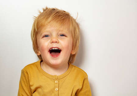 Close happy blond little boy portrait laughingの写真素材